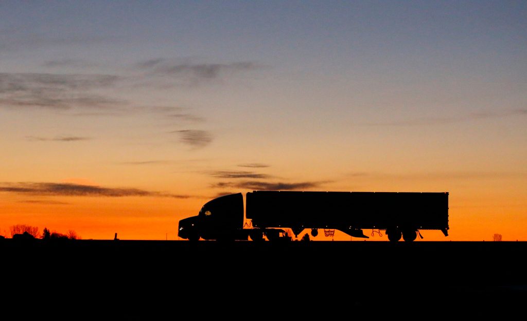 Silhouette of semi truck driving on highway